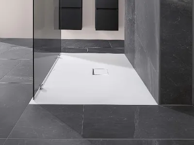 A modern bathroom with a Squaro Infinity shower tray, glass shower cubicle and grey tiles.