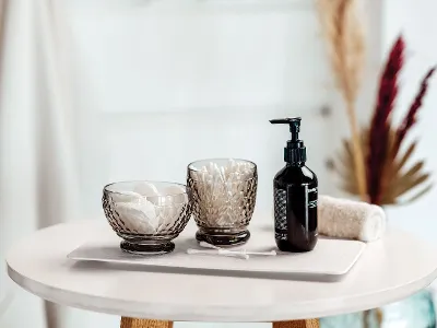 Two Villeroy & Boch black Boston water glasses used as stylish storage for cosmetic pads and cotton buds.