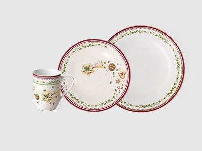 Ein Keramik-Geschirrset mit einer Tasse, einem Salatteller und einem Essteller mit Blumen- und Fruchtmustern.