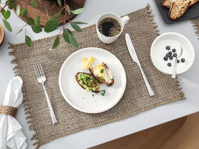 A table set with a cup of coffee and a Villeroy & Boch white Artesano plate with food.