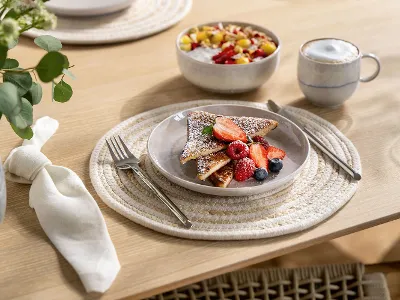 Boho-inspiriertes Frühstücks- und Dessertgedeck mit Villeroy & Boch Perlemor Sand Geschirr – Becher, Müslischale und Teller – auf rustikalem Holztisch mit natürlichem, entspanntem Charme.