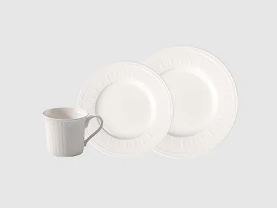 Eine weiße Keramiktasse und zwei passende weiße Essteller werden vor einem schlichten hellen Hintergrund präsentiert.