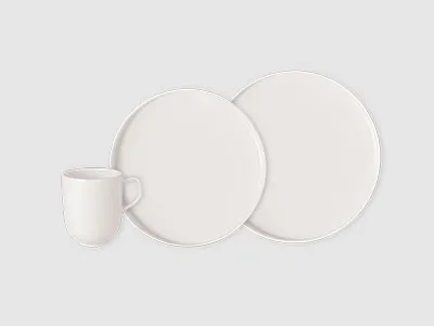 Eine weiße Keramiktasse und zwei weiße runde Teller sind vor einem schlichten hellgrauen Hintergrund angeordnet.