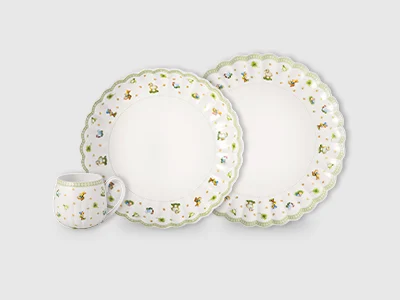 Collection Image - Easter Delight An arrangement of two plates of different sizes and a cup, decorated with green, spring-like accessories, presented on a light background.