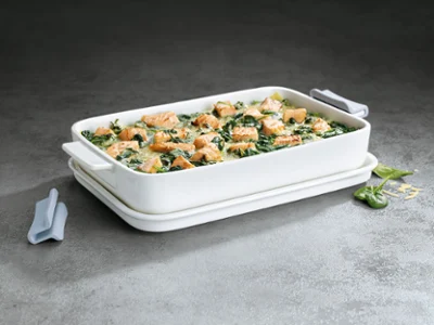 A white Clever Cooking casserole dish filled with salmon casserole A white Clever Cooking casserole dish filled with salmon casserole against a grey background.