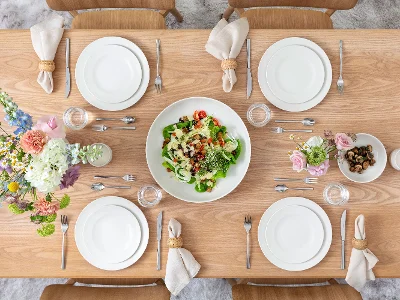 Vue de dessus d’une table printanière pour quatre personnes sur une table en bois. L’ensemble inclut la collection For Me de Villeroy & Boch : assiettes plates, assiettes à déjeuner, bols et un grand saladier. Accompagné des élégants couverts Piemont et d’un bouquet de fleurs printanières, l’ensemble est léger, décontracté et accueillant.