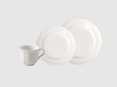 Eine weiße Tasse und zwei weiße Teller mit dezent gewellten Rändern werden vor einem schlichten hellen Hintergrund präsentiert.