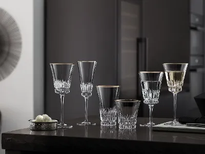 Elegant Grand Royal glasses on a counter in a modern kitchen with dark cupboards in the background.