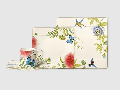 Ein vierteiliges Geschirrset mit Blumen- und Schmetterlingsmustern auf weißem Hintergrund.