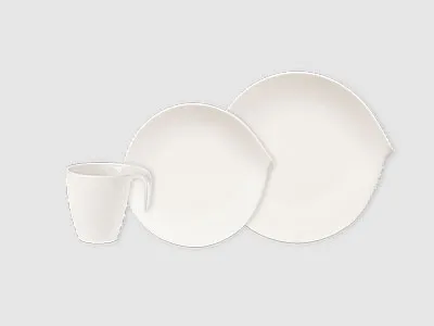 Drei weiße Keramikteller: eine Tasse, ein kleiner Teller und ein großer Teller, angeordnet auf einem schlichten hellen Hintergrund.