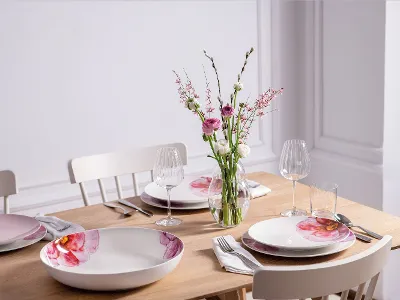 A modern dining table for four people with elegant Villeroy & Boch Rose Garden crockery and a flower vase from the Rose Garden collection.
