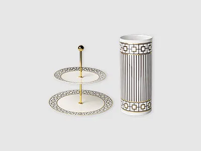 Zweistufiger Dessertständer und hohe zylindrische Vase, beide weiß mit schwarzen geometrischen Mustern und goldenen Akzenten.
