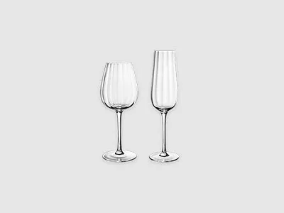 Ein Weinglas und ein Champagnerglas, beide leer, stehen nebeneinander vor einem schlichten hellen Hintergrund.