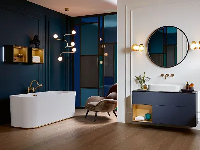 A bathroom with blue walls, with harmonious Finion bathroom furniture and a white Finion bath by Villeroy & Boch.