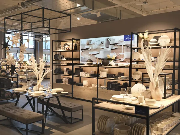Modern shop interior with a variety of ceramic crockery Modern shop interior with a variety of ceramic crockery and decor on black metal shelves and tables with soft lighting.