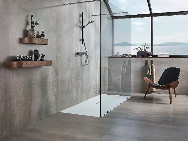 A modern grey bathroom with a Squaro Infinity shower tray and a brown chair.