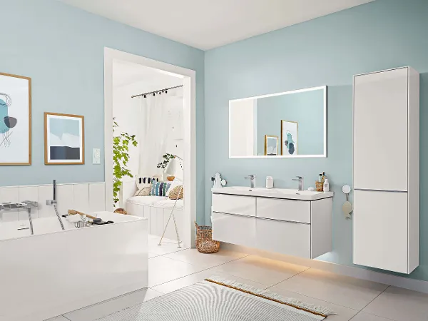 A white bathroom with blue walls and a flat illuminated Subway 3.0 mirror and coordinating bathroom furniture.