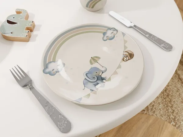 The Boho Kids | Walk like an Elephant children's plate by Villeroy & Boch features an elephant design on a table with a fork and knife, complemented by an elephant-shaped toy figure in the background.