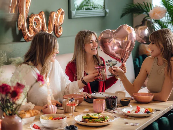 women having a valentine's day lunch with balloons that are heart shaped 