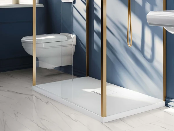 Biały, prostokątny brodzik Squaro Infinity ze złotymi armaturami Nowoczesna łazienka z niebieskimi ścianami, złotymi bateriami, wiszącym WC i oknem z naturalnym światłem.