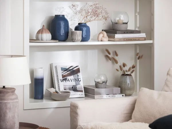 Blue Lave vases on a bookshelf A living room with bookshelves and blue Lave vases from like. by Villeroy & Boch.