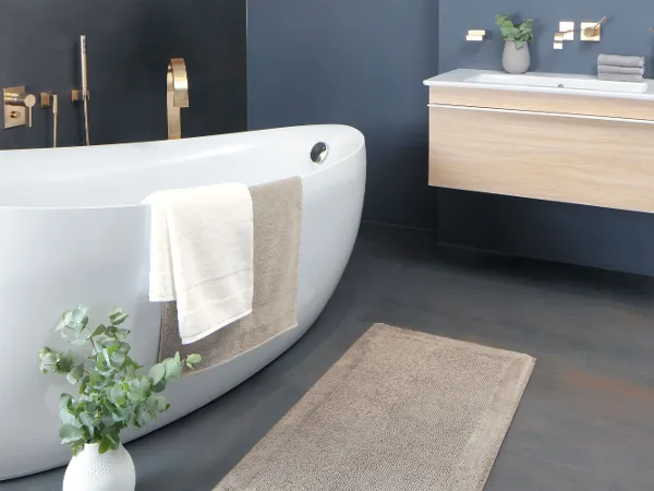 Villeroy & Boch bathroom textiles in a bathroom with a white bath and a wooden washstand.