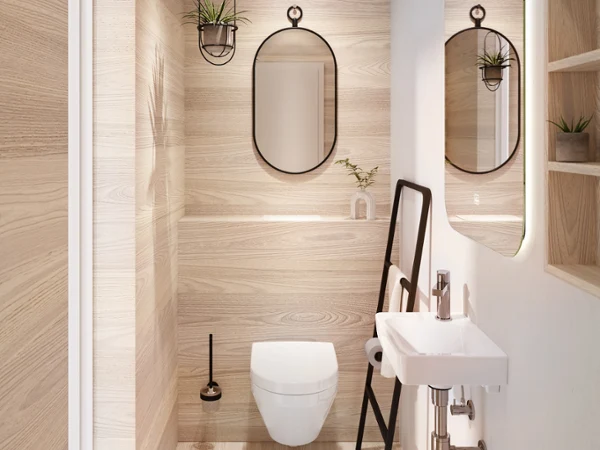 Toaleta i miska WC Architectura marki Villeroy & Boch w kolorze białym Nowoczesna łazienka z boazerią z jasnego drewna, toaletą wiszącą, okrągłym lustrem, małą umywalką z odsłoniętymi rurami i czarną drabinką na ręczniki. Na półkach stoją rośliny i przybory toaletowe.