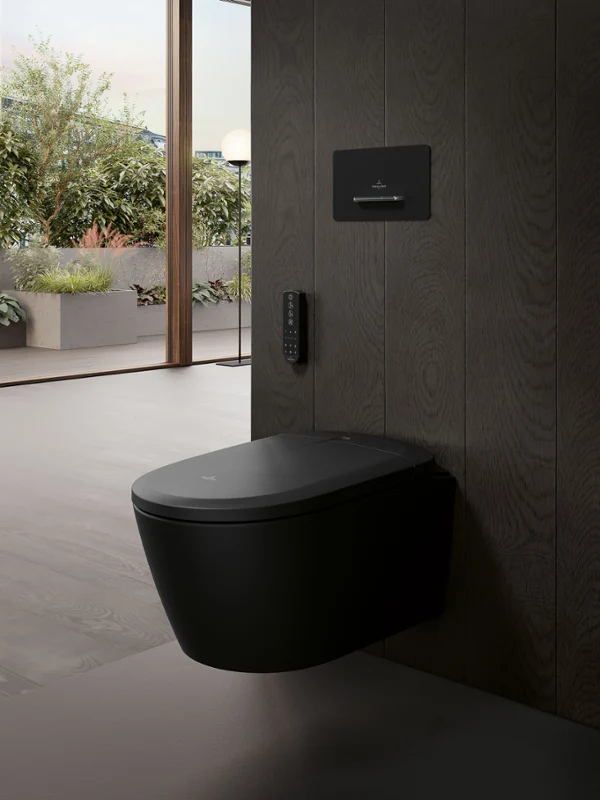 Czarna toaleta myjąca Supreo wisząca na ścianie w luksusowej łazience Zbliżenie na ekskluzywną toaletę myjącą Supreo w matowej czerni, z kolekcji Finion All Black, w luksusowej łazience z widokiem na taras.