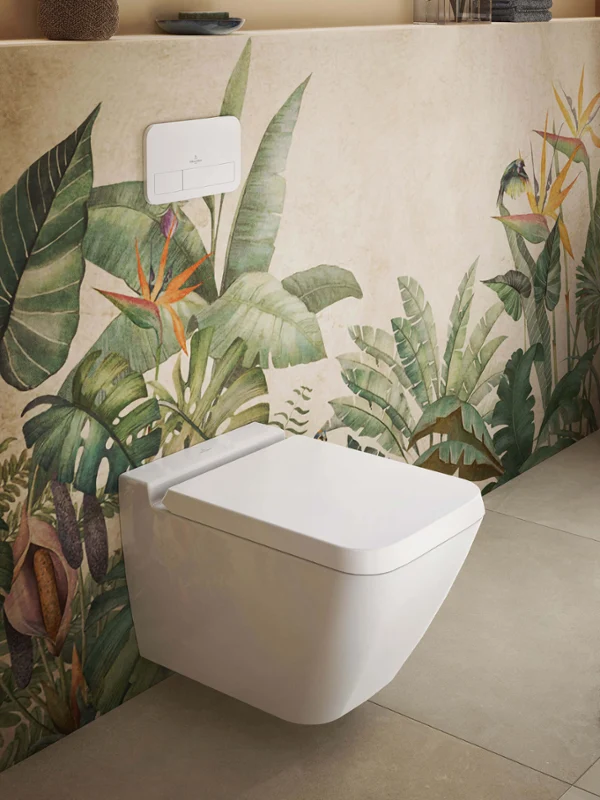 White Finion toilet and seat in front of plant wallpaper A wall-mounted Finion toilet with a seat and lid installed on a pre-wall with a plant pattern.