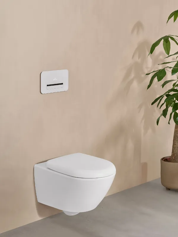 A white Antao toilet by Villeroy & Boch in an elegant beige bathroom with a potted plant.