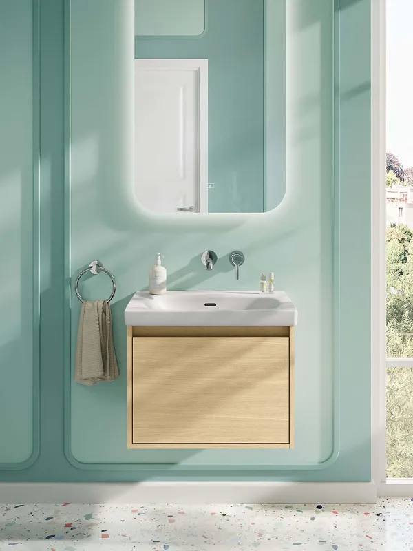 Der Waschplatz in diesem fröhlichen, mintgrünen Badezimmer setzt sich aus einer Kombination von Waschbecken und Unterschrank aus der Skyla Badkollektion sowie dem beleuchteten Spiegel mit abgerundeten ecken aus der More To See Lite Kollektion zusammen.