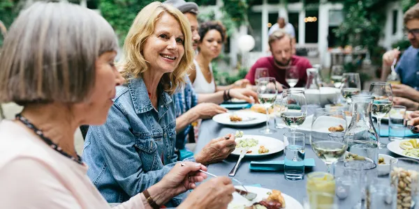 A set table where several people are eating and talking in the garden