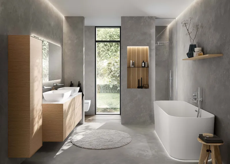 Baderom i minimalistisk stil Minimalistisk baderom med Villeroy & Boch Finion-badekar, Finion-servantskap og to Artis-vasker. Det enkle designet kombinerer naturlige treelementer med moderne grå vegger og en stor vindusfront for å skape en lys og rolig atmosfære.