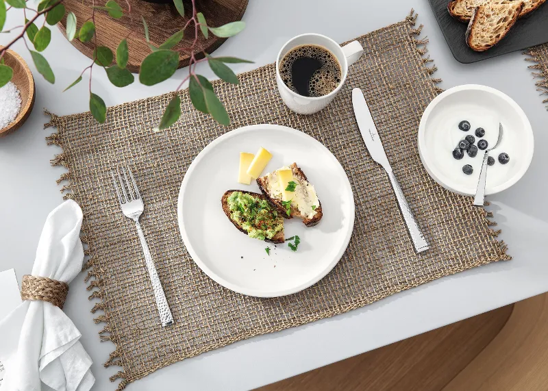 A table set with a cup of coffee and a Villeroy & Boch white Artesano plate with food.