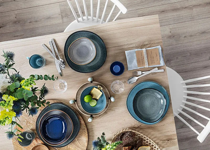 A wooden table with Villeroy & Boch Lave plates on top.