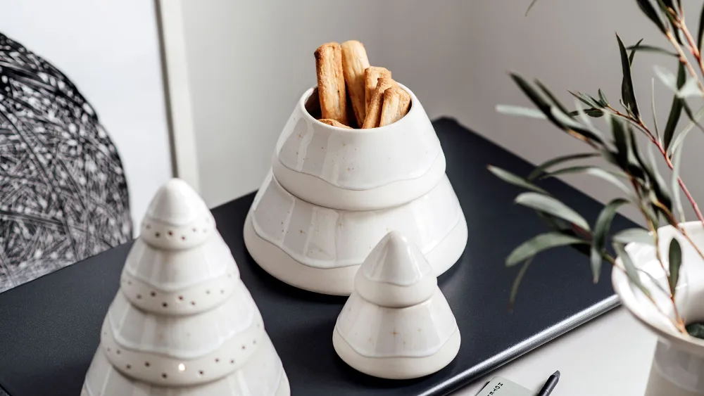 A table with Villeroy & Boch Winter Glow decoration and a biscuit tin.