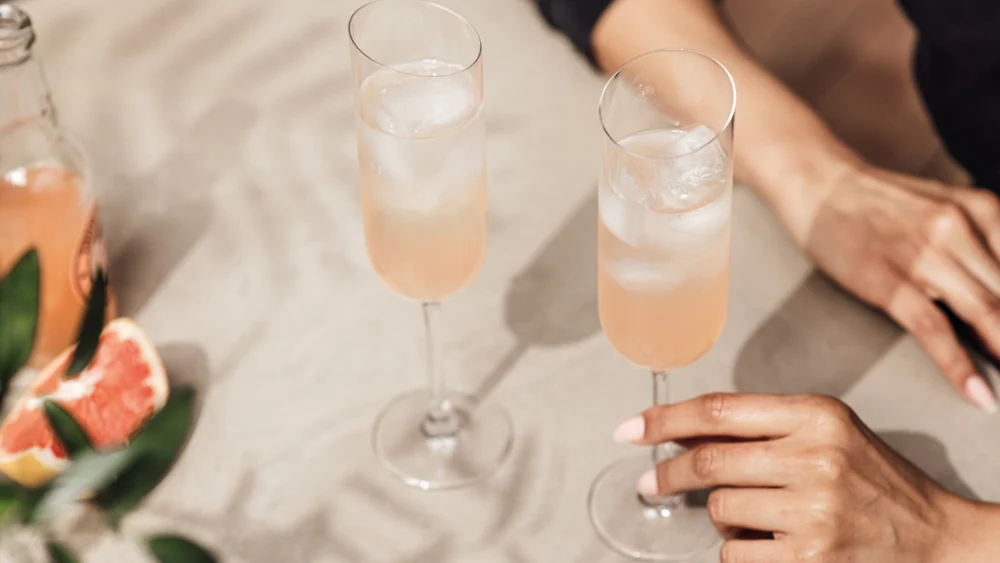 Persoon met een NewMoon champagneglas met een sprankelende drank erin