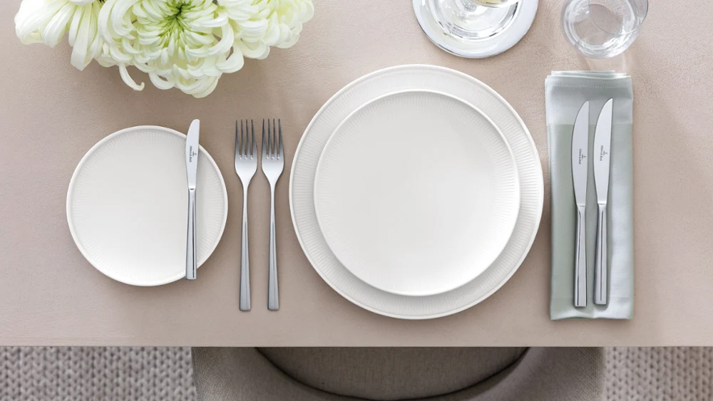 Table setting with Afina dinnerware with visible floating effect A set table with Afina plates from a sideways angle to see the floating effect of the plates.