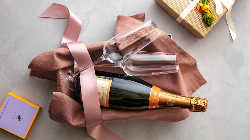Een fles champagne samen met Rose Garden champagneglazen van Villeroy & Boch in een cadeaubox.