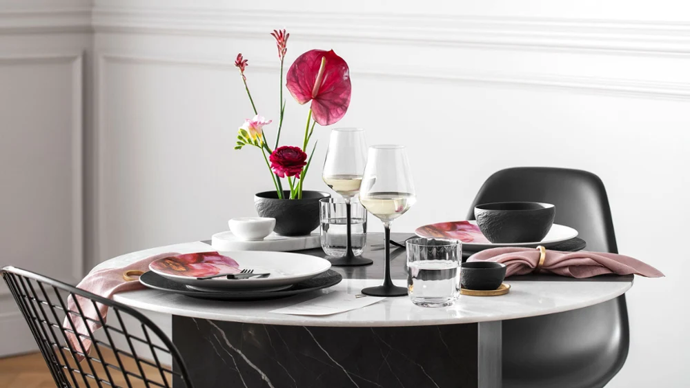 Een gedekte eettafel voor twee personen met NewMoon, Manufacture en Rose Garden servies van Villeroy & Boch.