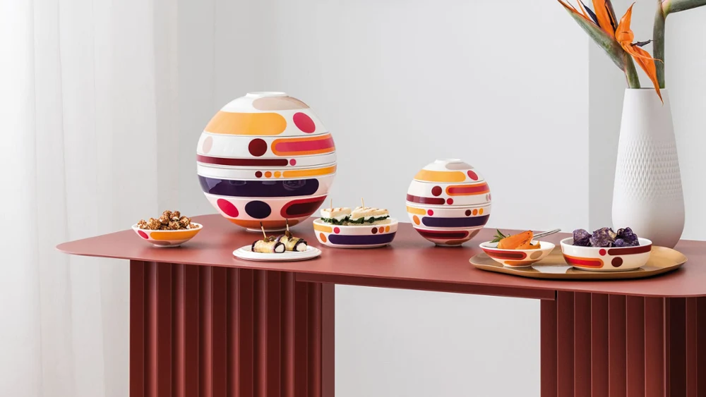La Boule and La Petite Boule, a white Manufacture Collier blanc vase A modern interior with La Boule and La Petite Boule, a white Manufacture Collier blanc vase with orange flowers, and abstract wall art in muted tones.