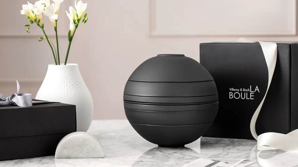 La Boule Black with gift box A black La Boule tableware set on a table with a black gift box behind it.