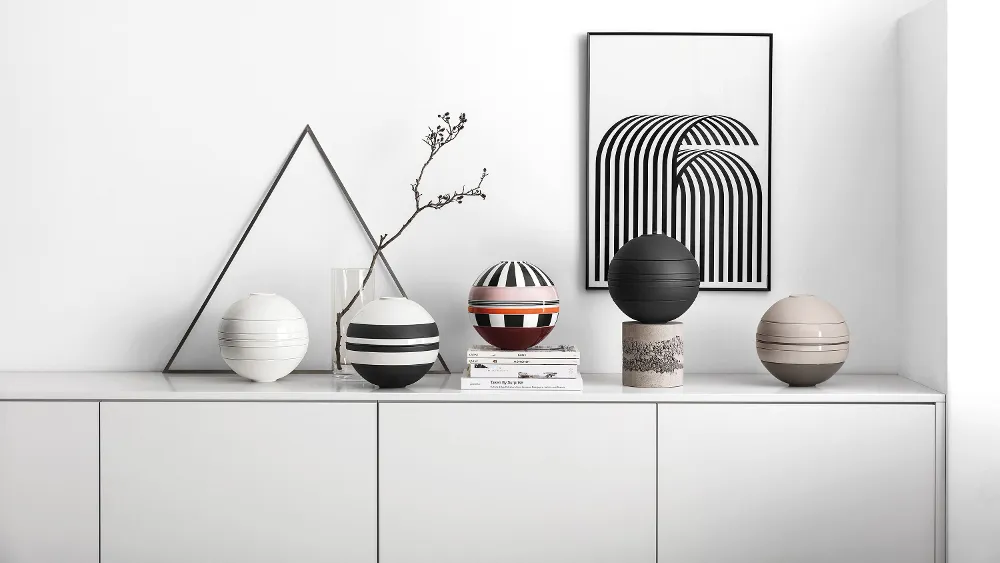 Five La Boule crockery sets on a white shelf A white shelf with several La Boule crockery sets on top.