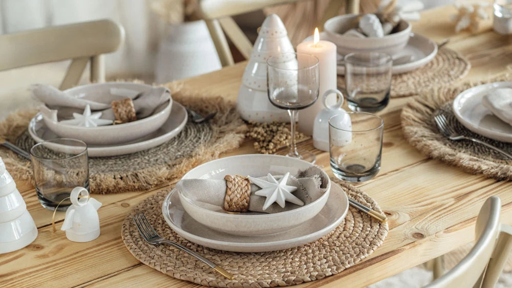 Elegante mesa de comedor con decoración Winter Glow y vajilla Perlemor de Villeroy & Boch. Las velas crean un ambiente de fiesta.