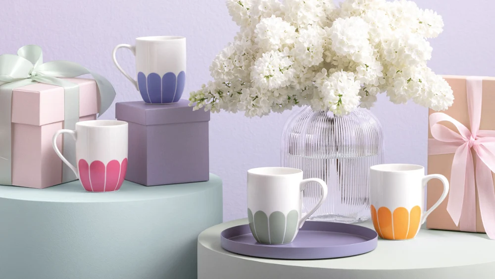 Villeroy & Boch Fleur cups in pastel colours, a Fleur vase, gift boxes and a white flower vase on softly toned surfaces.
