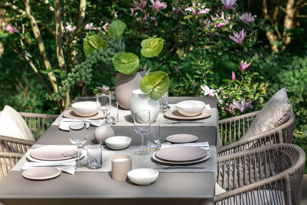 Set table with NewMoon collection A dining table with NewMoon dinnerware from Villeroy & Boch in a garden.