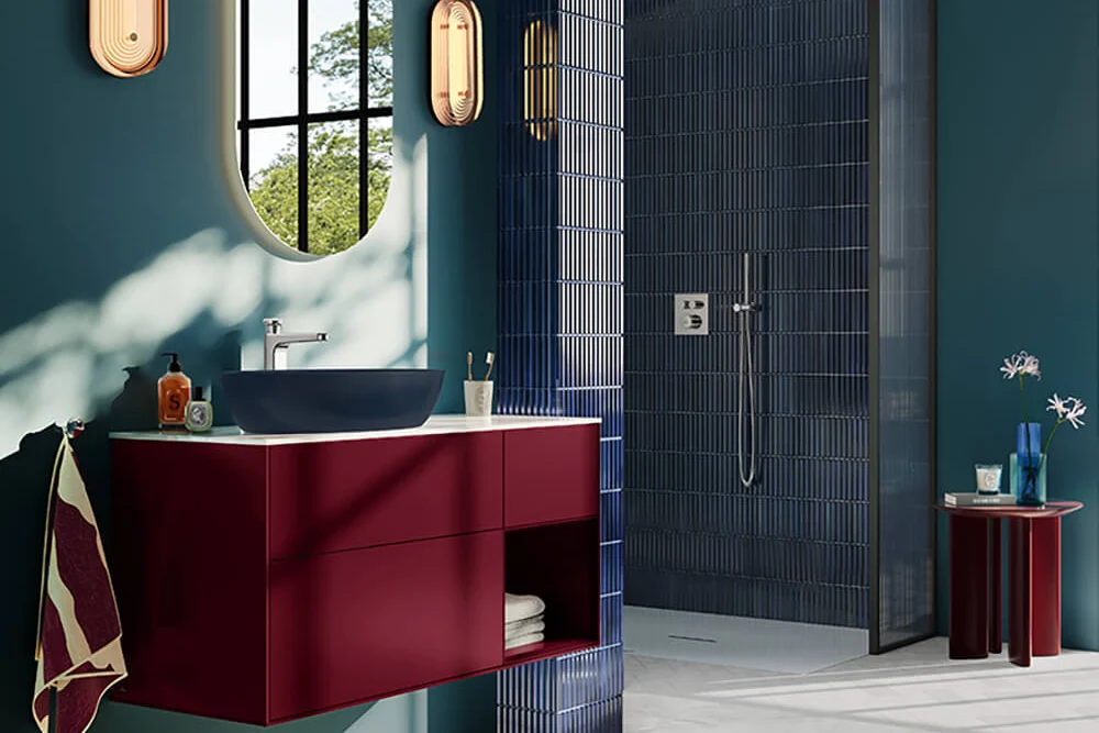 Contemporary bathroom with teal walls and a striking red vanity unit A chic, modern bathroom featuring dark teal walls and a floating deep red vanity unit with a white countertop and a dark blue surface-mounted Artis washbasin.