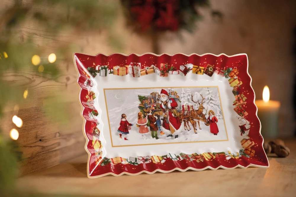 Toy's Fantasy rectangle platter Festive ceramic tray with red scalloped edges, depicting a winter scene with Santa, children, and reindeer, surrounded by gifts. Cozy ambiance.