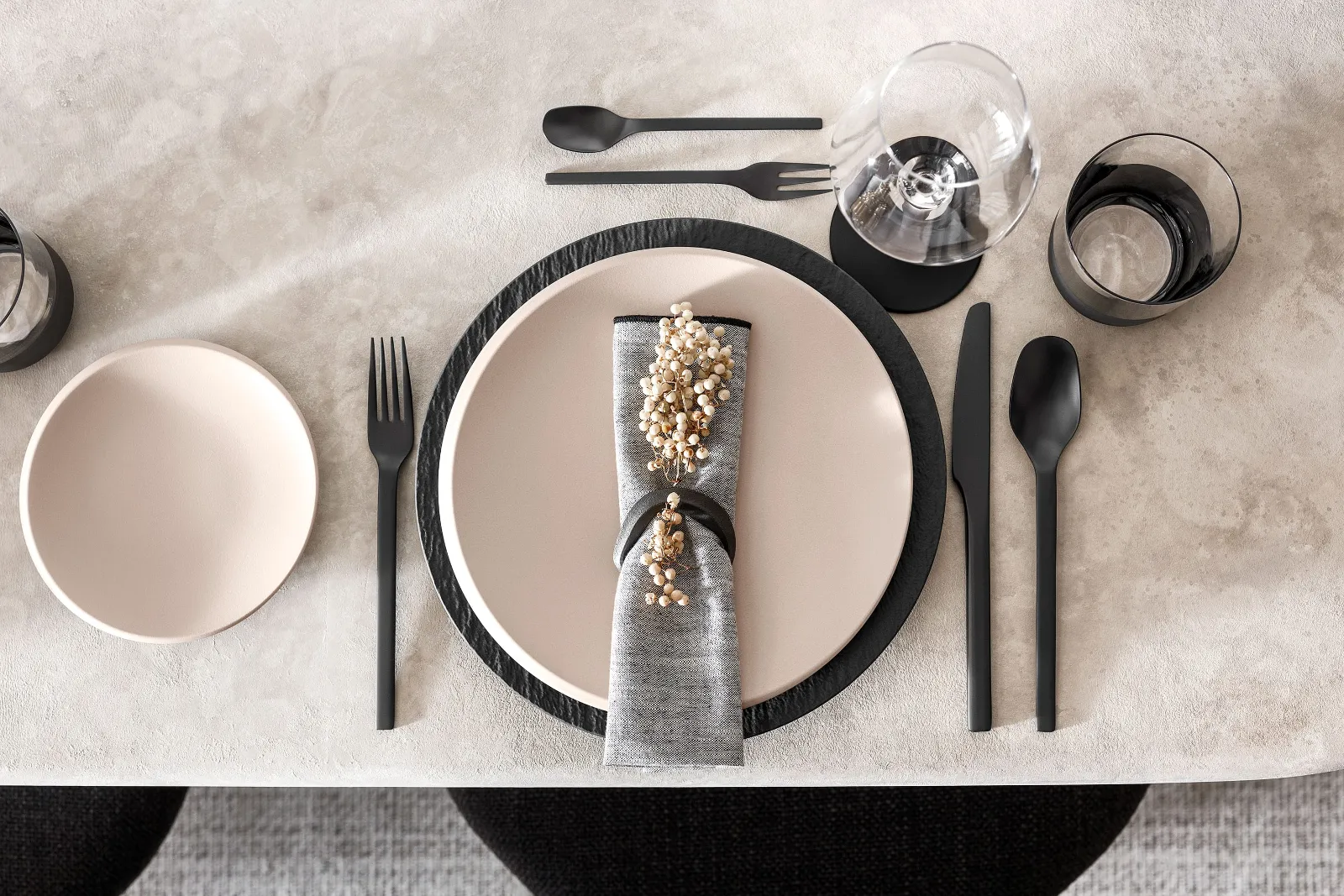 Modern table decoration with NewMoon crockery in beige and black Manufacture cutlery.