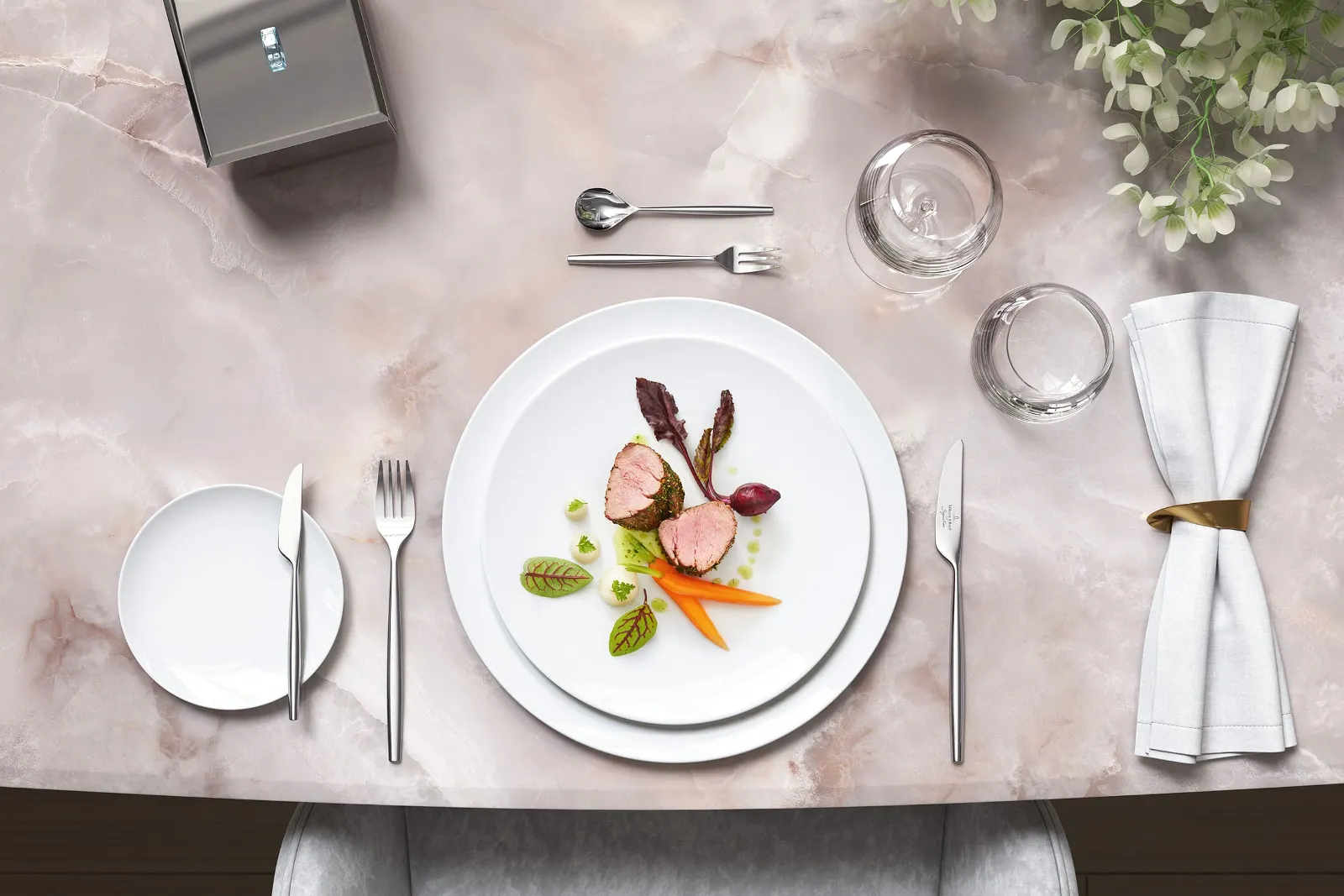 Stylish marble table with gourmet food on white MetroChic plates, together with MetroChic cutlery and floral decorations.